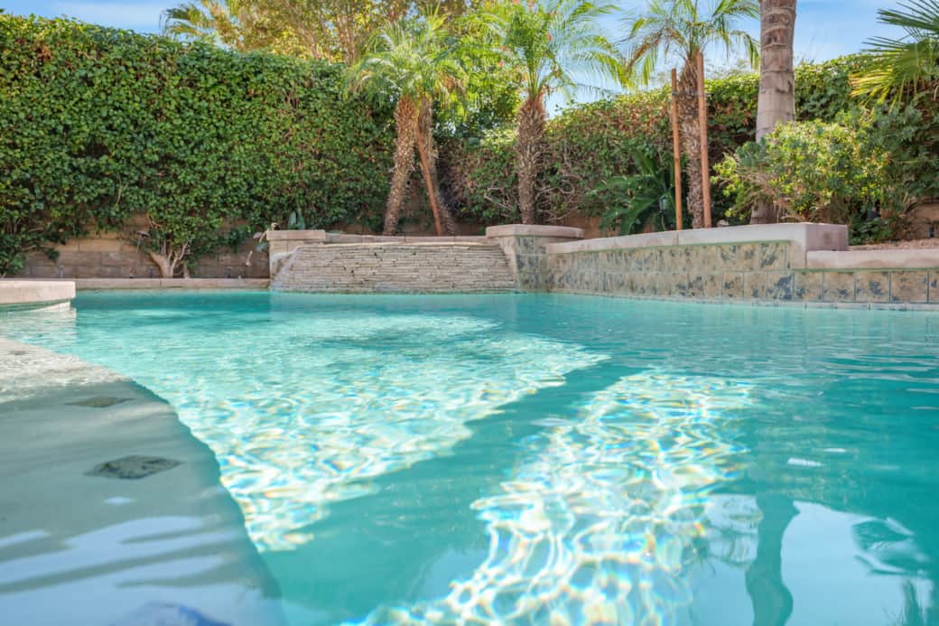 The water is a bright, inviting turquoise blue, with strong sun reflections indicating a sunny envir The water is a bright, inviting turquoise blue, with strong sun reflections indicating a sunny envir