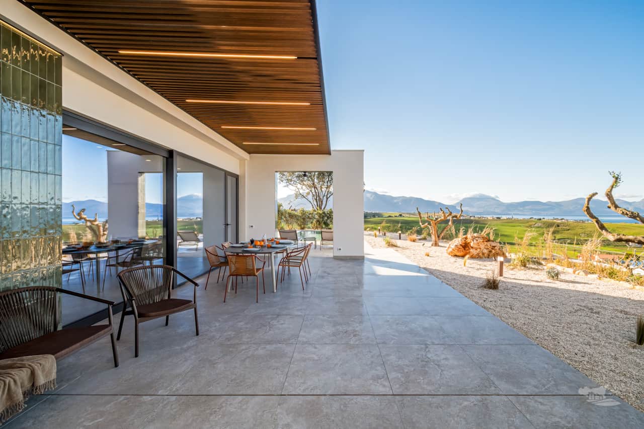Veranda view where the endless blue Mediterranean meets the rolling Sicilian hills.