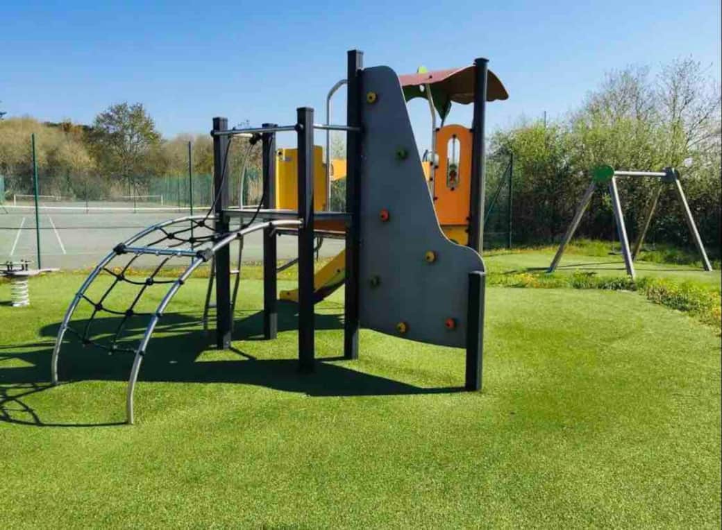Aire de jeux, balançoire et terrain de pétanque.