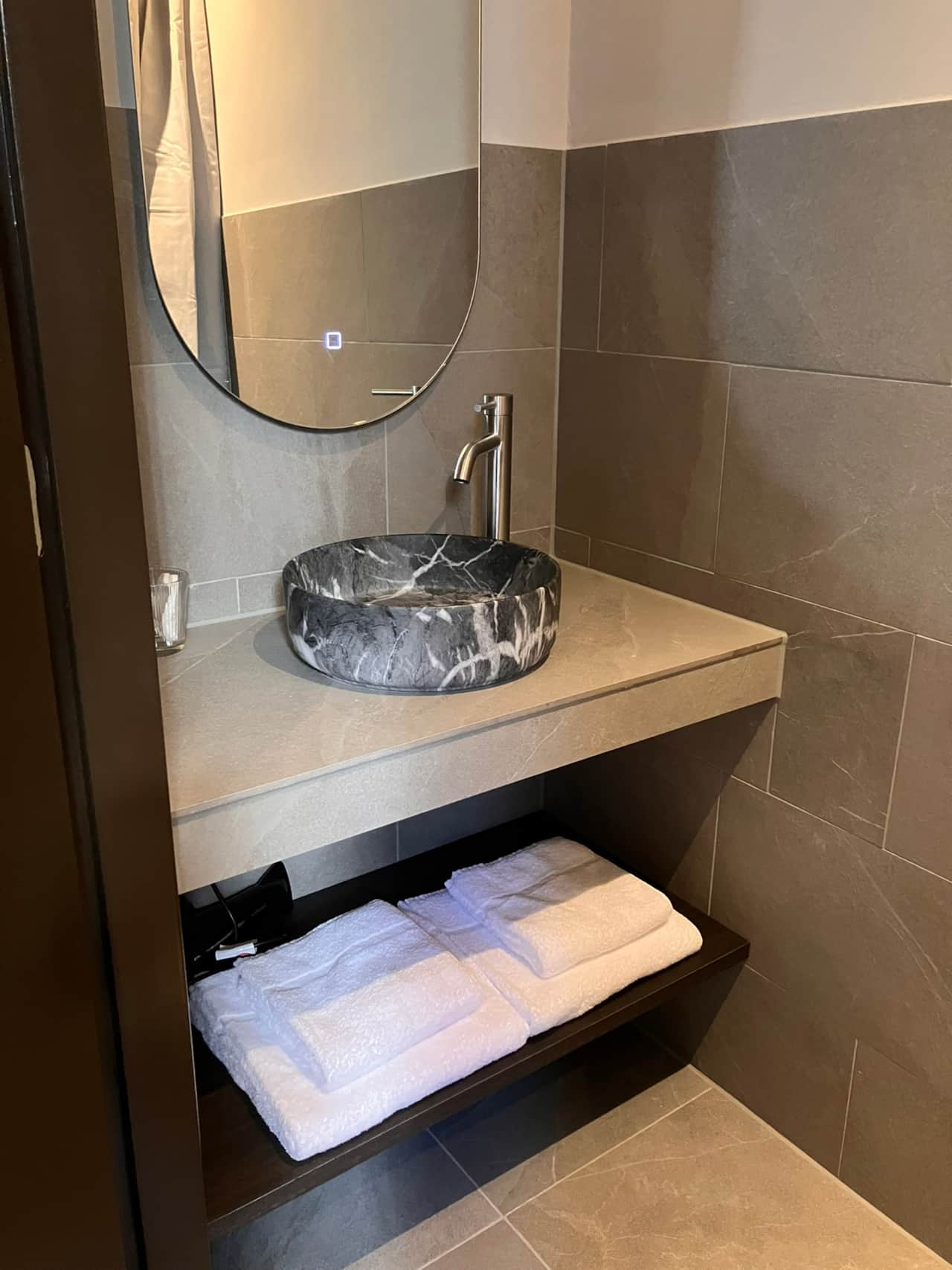 Elisabeth Suite bathroom vanity with a round stone vessel sink and folded towels