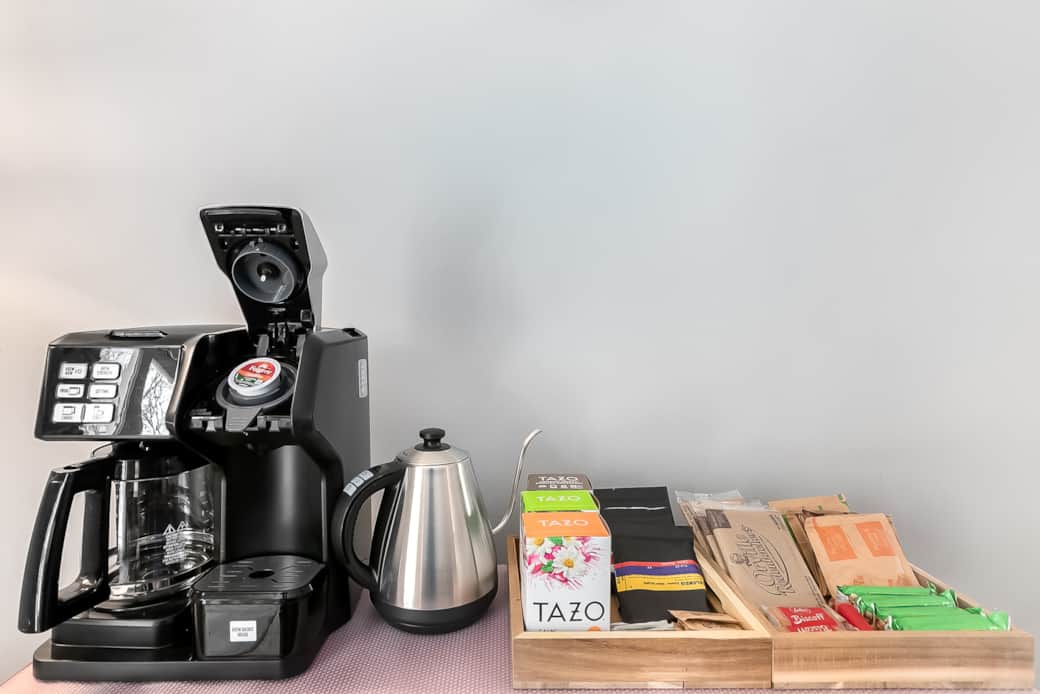 The coffee bar is stocked with coffee teas and more. The coffee maker brews both single and carafe.