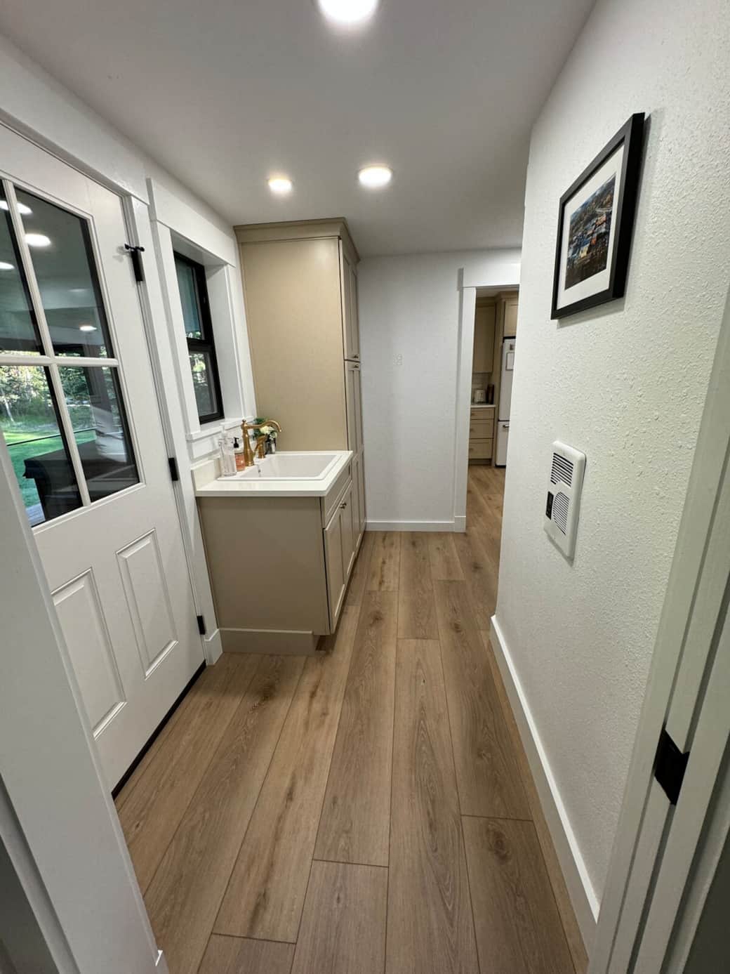 Connect the hallway from the chef's kitchen to the living room. Utility sink, LG washer & dryer, and 1/2 bathroom. This hallway leads to the covered back deck.