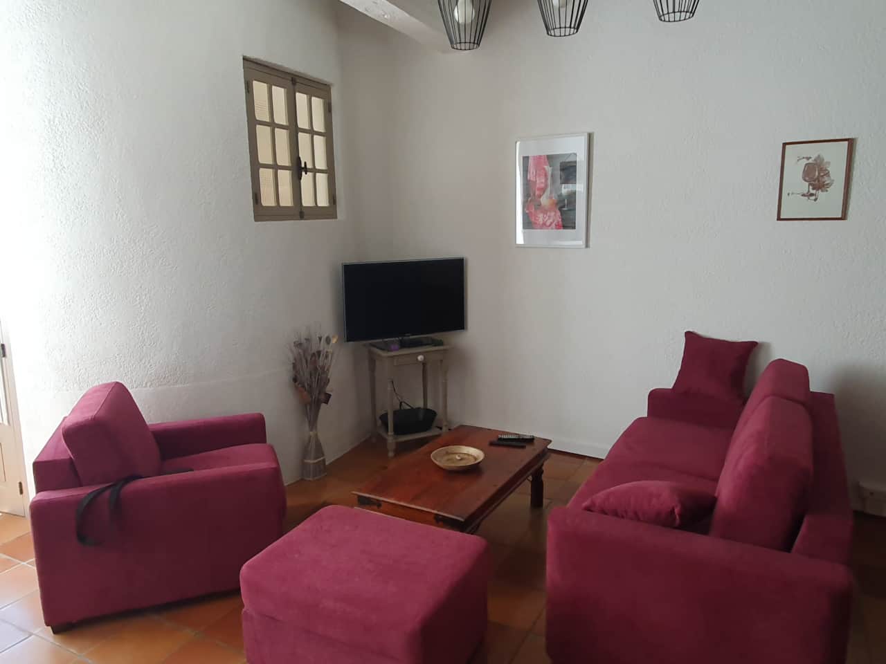 Living room : sofa bed, armchair, pouffe, coffee table and TV with decoder