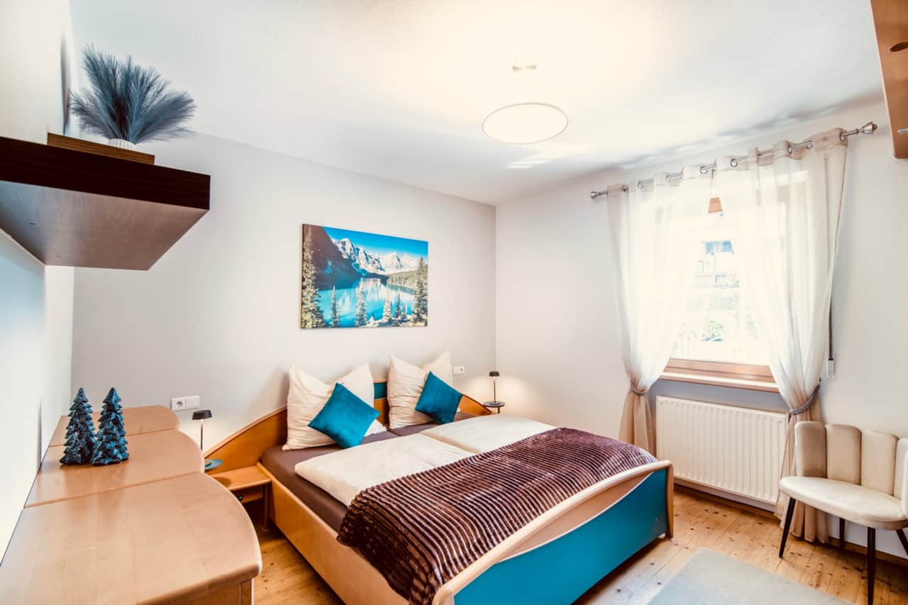 Ruhiges Schlafzimmer mit Doppelbett und Bergblick.