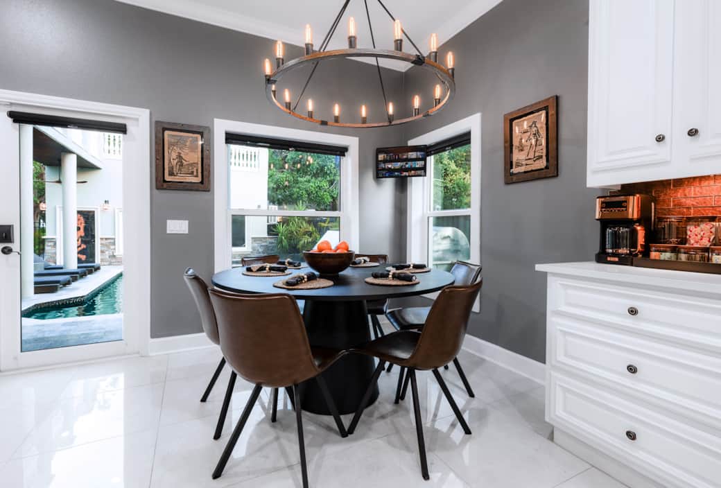 Cozy kitchen nook with pool views, pirate art, and a coffee bar tucked beneath warm amber lighting. Cozy kitchen nook with pool views, pirate art, and a coffee bar tucked beneath warm amber lighting.