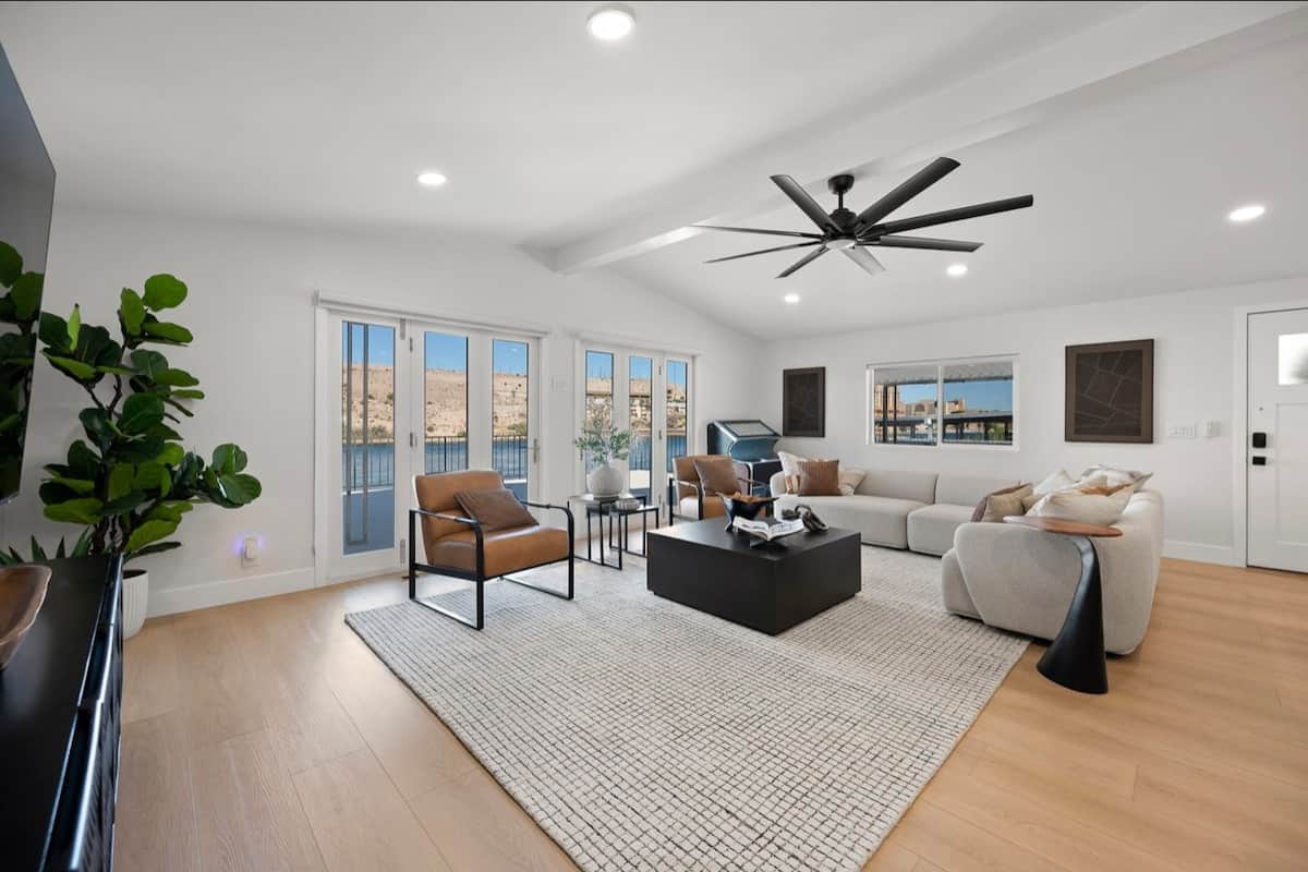 Relax in our bright, open concept living room featuring comfortable seating, soaring vaulted ceiling, and stunning river and mountain views through expansion windows. 