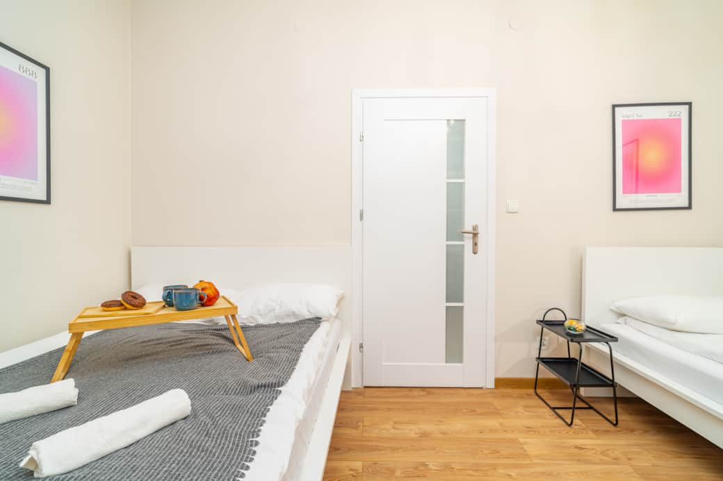 Bright bedroom with two single beds, minimalist design and a calm, relaxing atmosphere.