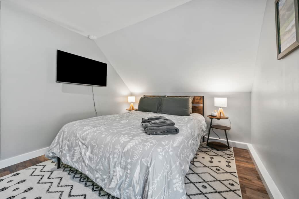 A comfortable bed with a smart tv next to it. A comfortable bed with a smart tv next to it.