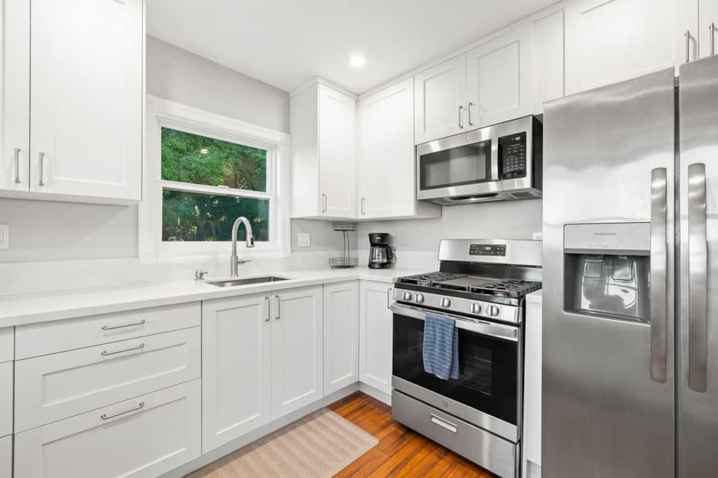 Bright and modern kitchen with a peninsula, stainless steel appliances, and garden views.