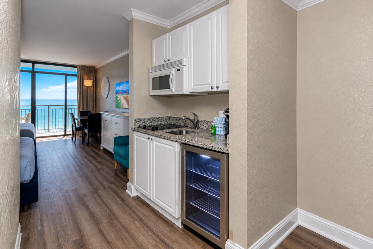 Convenient kitchenette with an under-counter fridge, microwave, sink, and plenty of counter space.