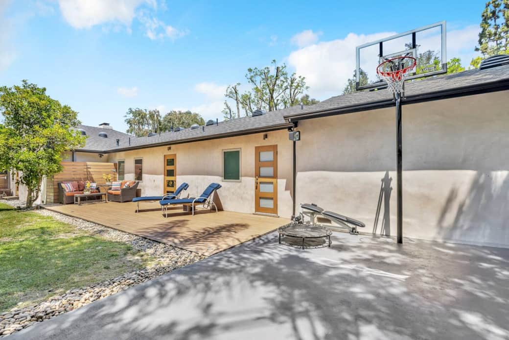 This part of the backyard offers an outdoor lounging area complete with a fun trampoline for kids to