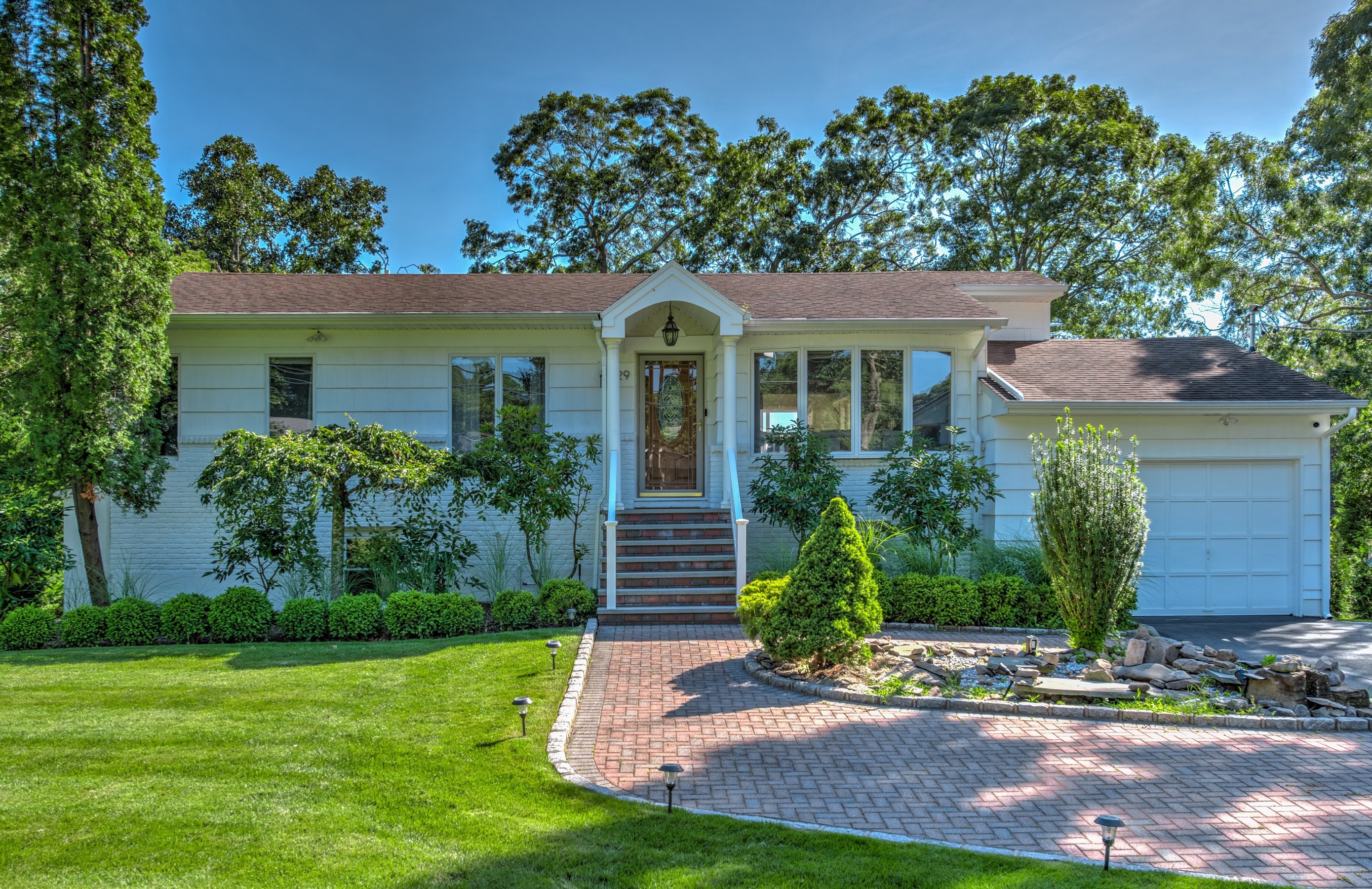 Front of the house with paver driveway and attached garage