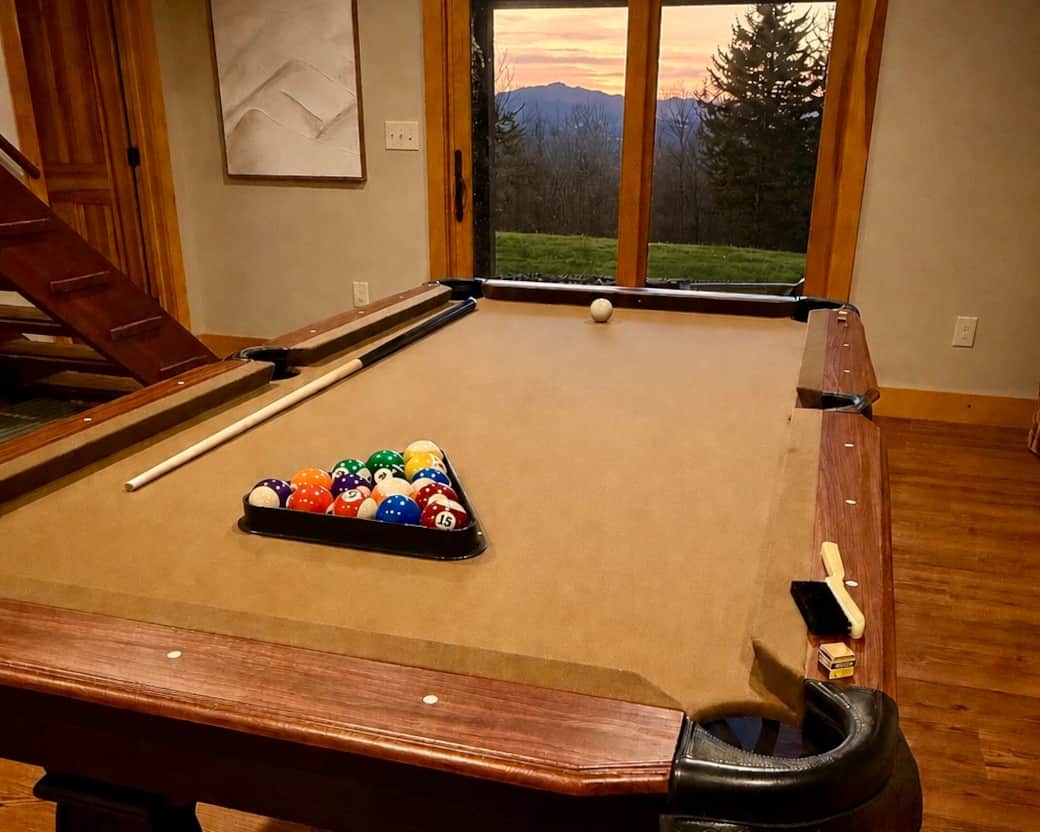 Game room with pool table and vintage Vermont ski art—perfect for friendly competition and après-ski vibes.