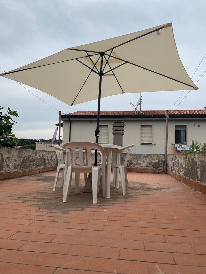 Terrazza con tavolo da pranzo e ombrellone