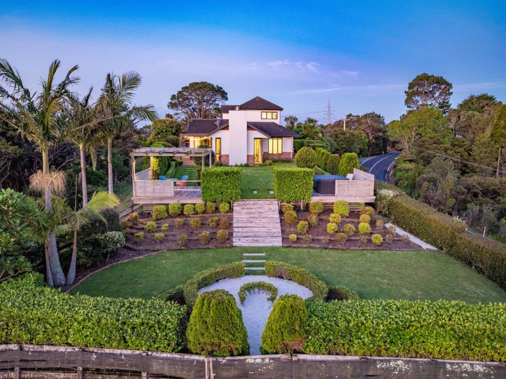 View from the back garden towards the back of the house.  The property has a large array of landscaped gardens to enjoy (dusk)
