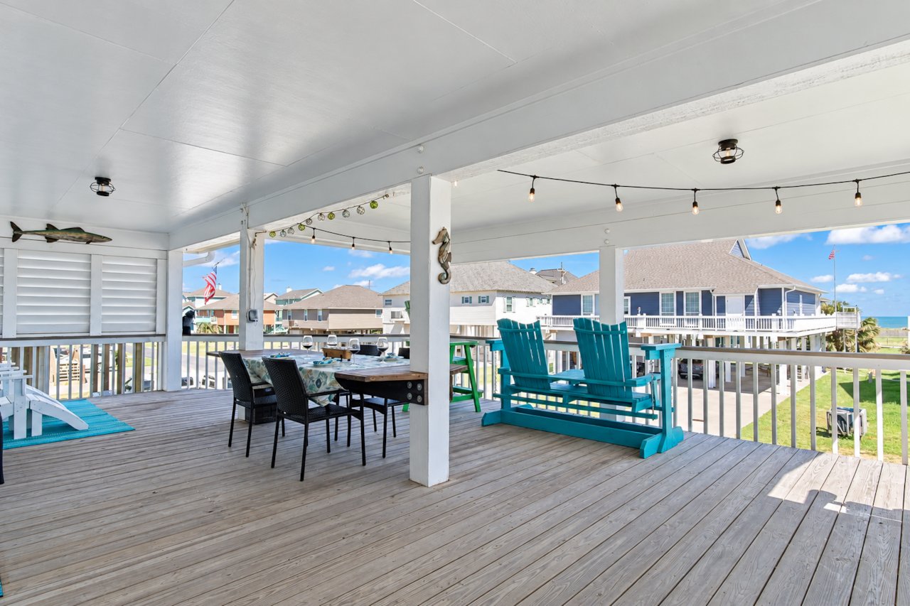 Shaded front deck with Adirondack chairs and outdoor dining