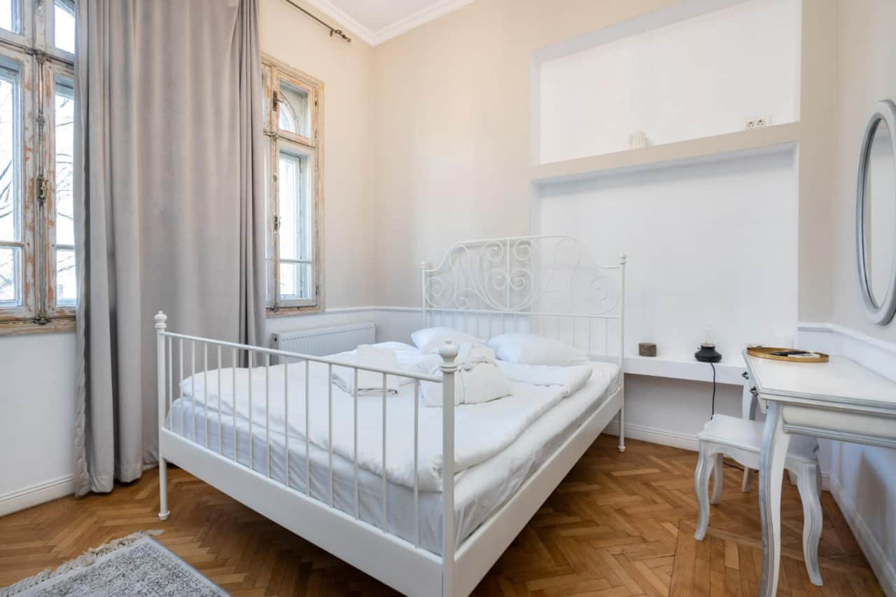 Bright bedroom with large windows in Central Bucharest apartment