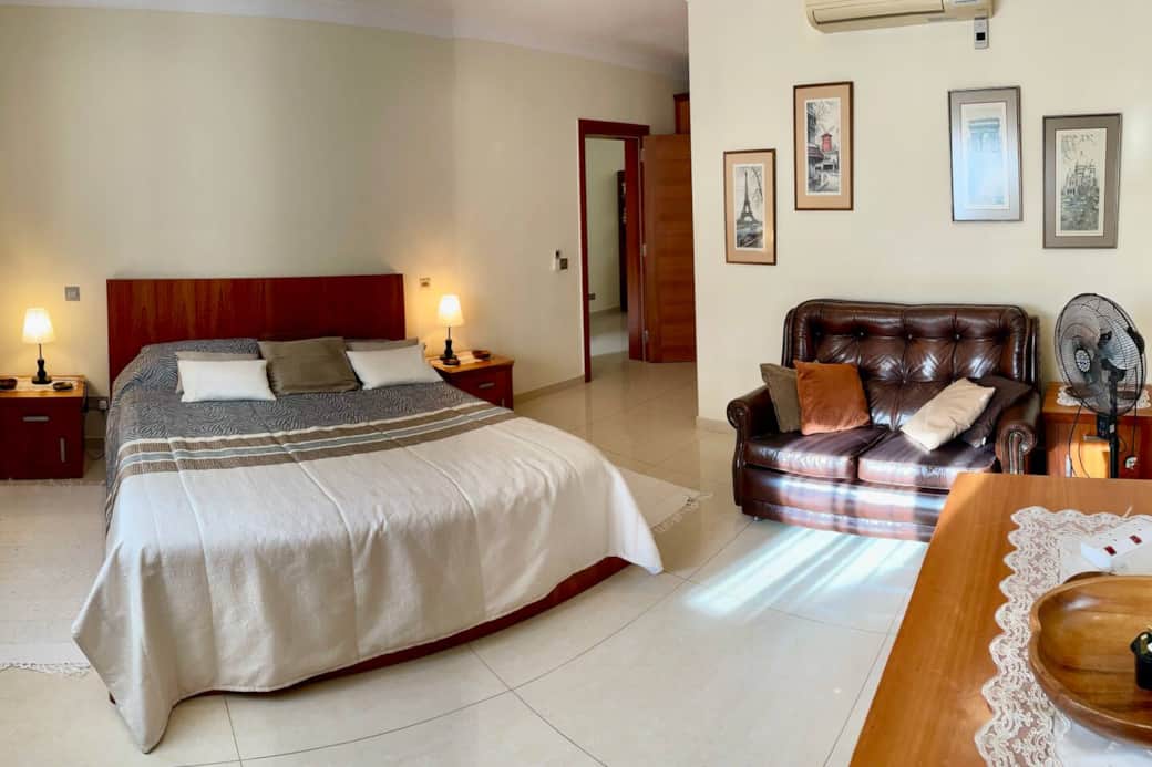 Master bedroom - Large double bed and a two seater full leather sofa.