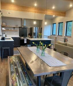 Custom dining table with homemade ski bench and view of kitchen