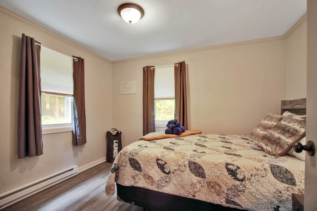 Bedroom 1, Queen bed, floor fan. 