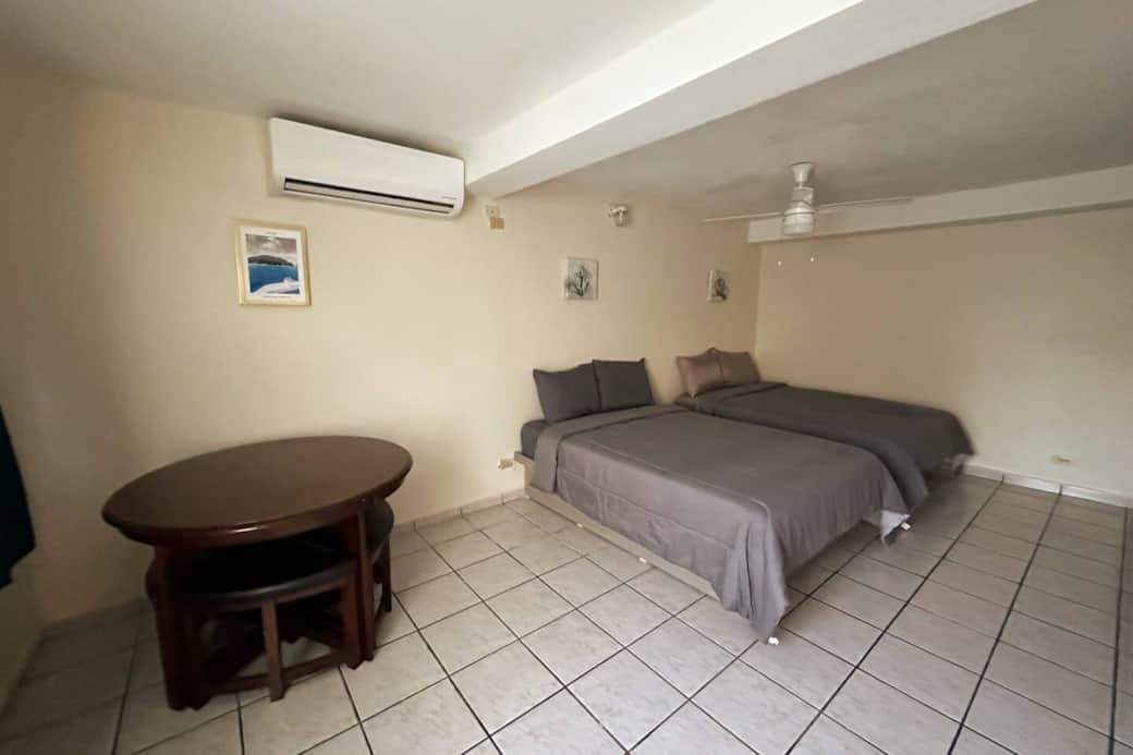 Spacious room with two full beds and place for dinner.