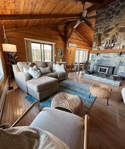 A rustic stone fireplace and cathedral ceilings create a warm and relaxing ambiance.
