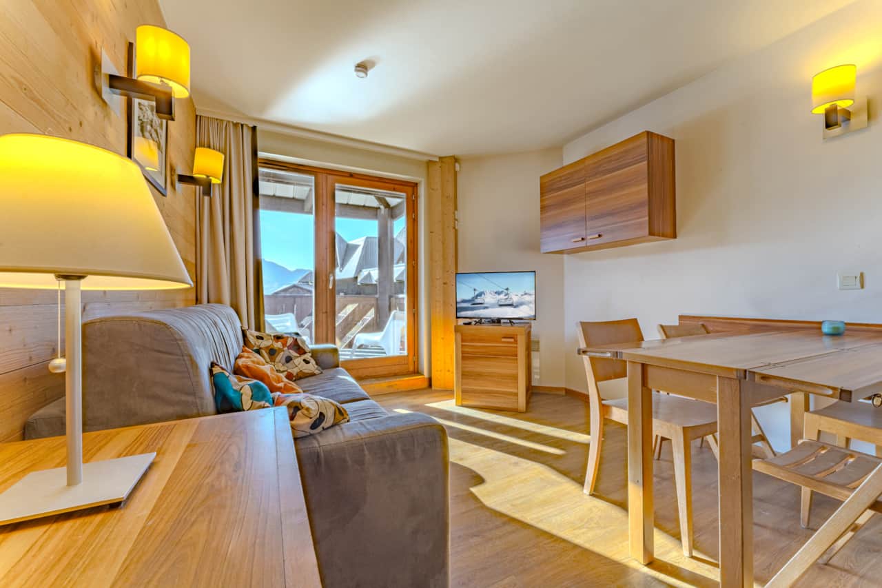 Salon avec canapé et table à manger près du balcon — Machu Mountains, Val Thorens