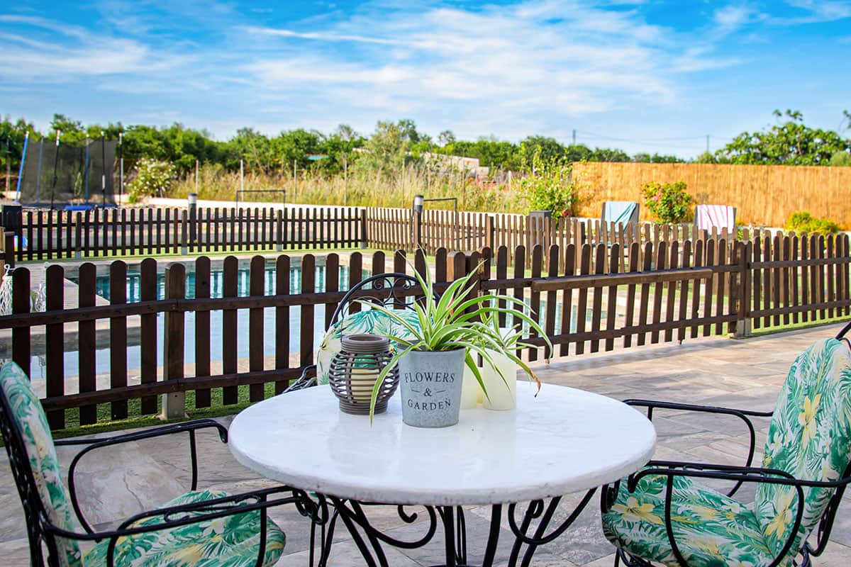 Terraza con mesa exterior y vistas al jardín vallado | Masía de Cholito 