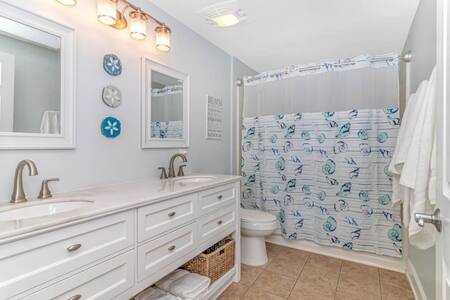 Spacious updated modern bathroom w/ double vanity and full bathtub.