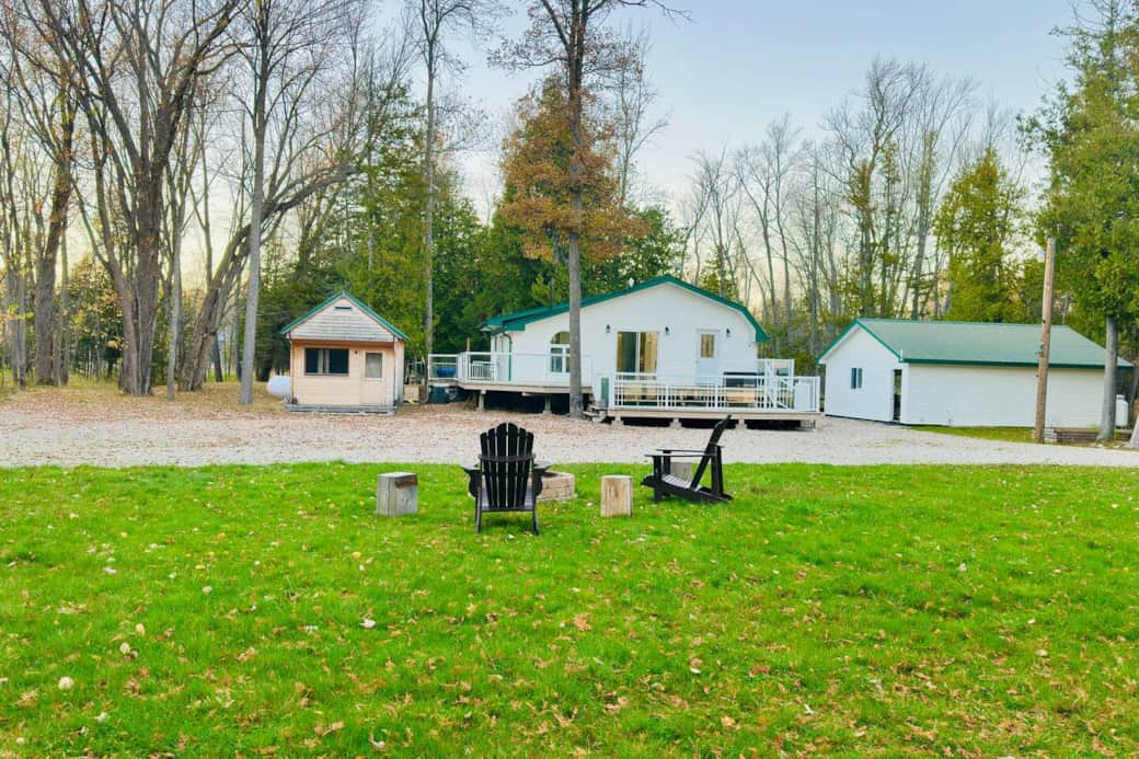 Spacious private property with firepit seating, surrounded by peaceful trees.