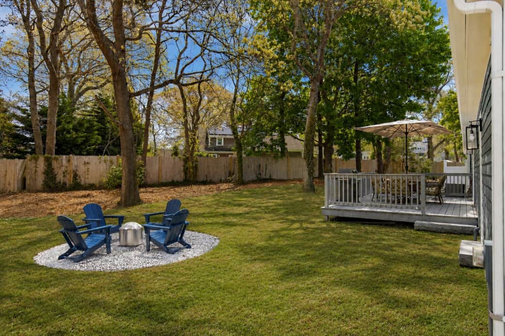 Backyard fire pit area surrounded by mature trees