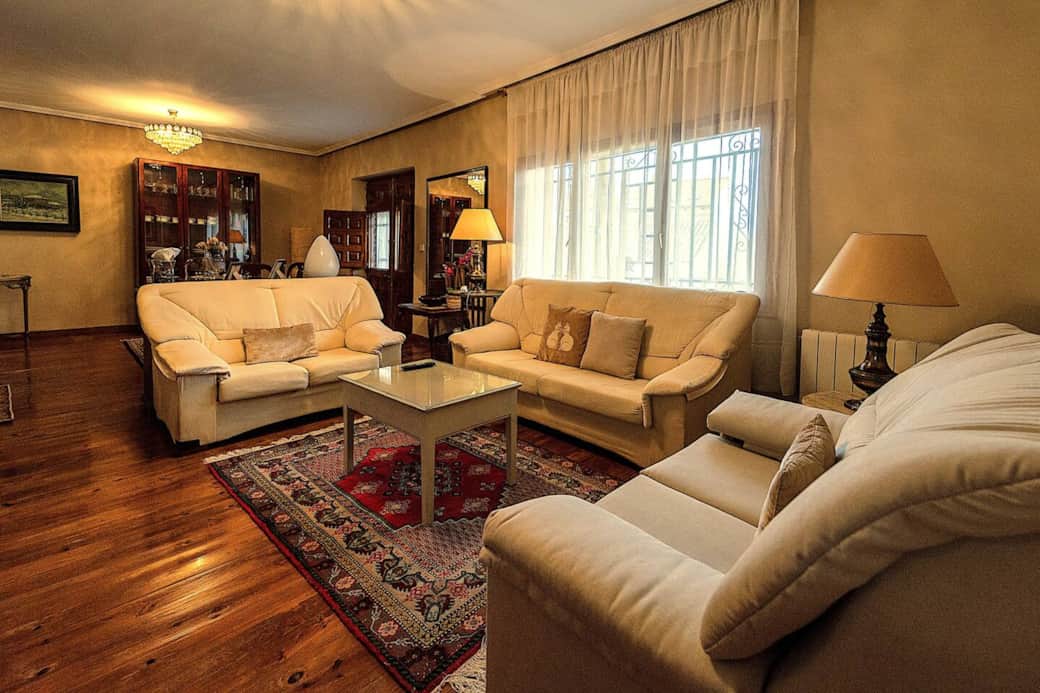 Salón con 3 sofás y salida a la terraza