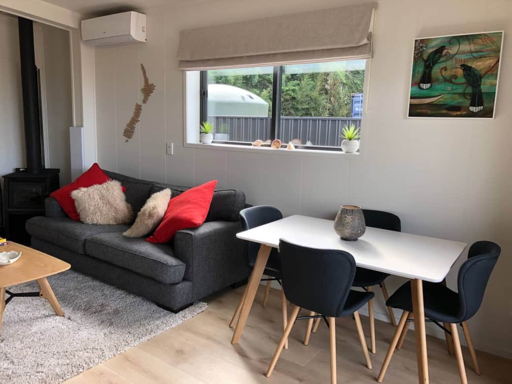 Dining and lounge area.. Air conditioning or open up the sliding doors with retractable insect screens. Designed to be cosy at night by the fire but a beautiful warm sunny space in the day. 
