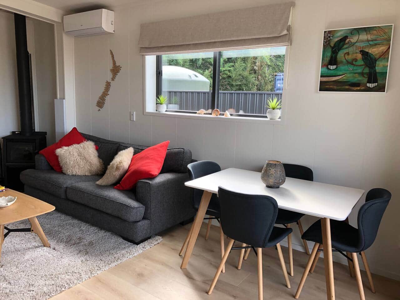 Dining and lounge area.. Air conditioning or open up the sliding doors with retractable insect screens. Designed to be cosy at night by the fire but a beautiful warm sunny space in the day. 