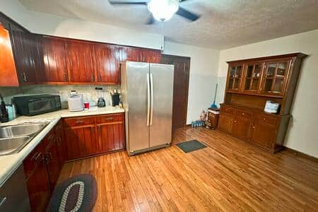 Fully stocked kitchen with Ice maker, hutch, microwave and double door stainless steel refrigerator.