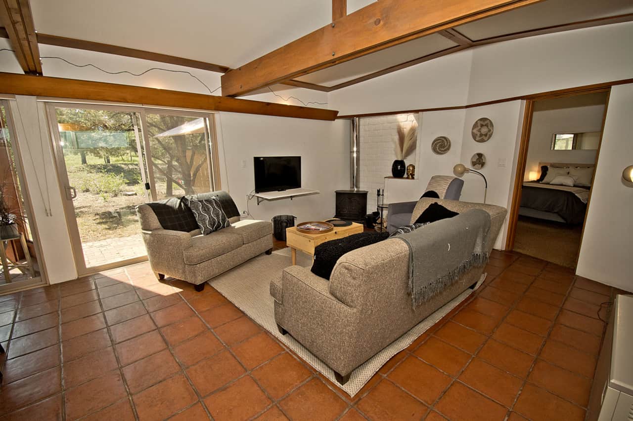 Living Room Area with TV and Access to Patio Area and Trails