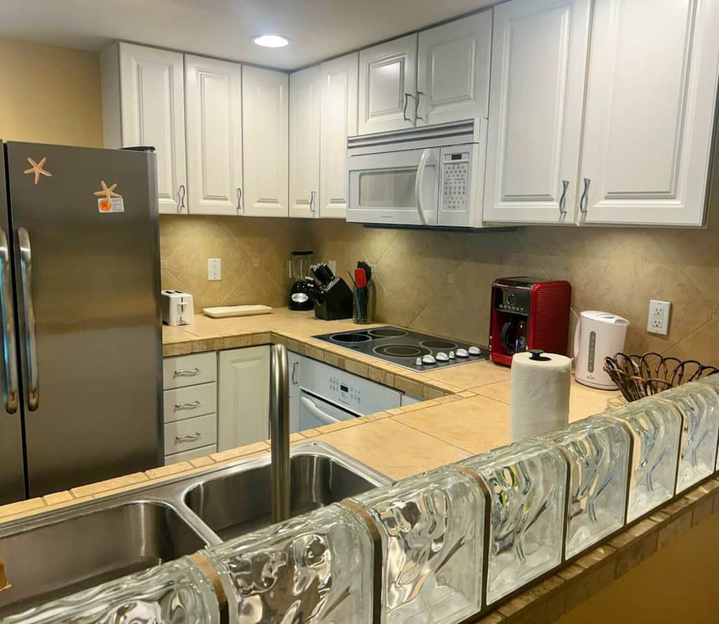 The cabinets are fully stocked with dinnerware and a variety of glasses, perfect for wine, champagne, pints and water, plus a variety of pots, pans, and other cooking tools.