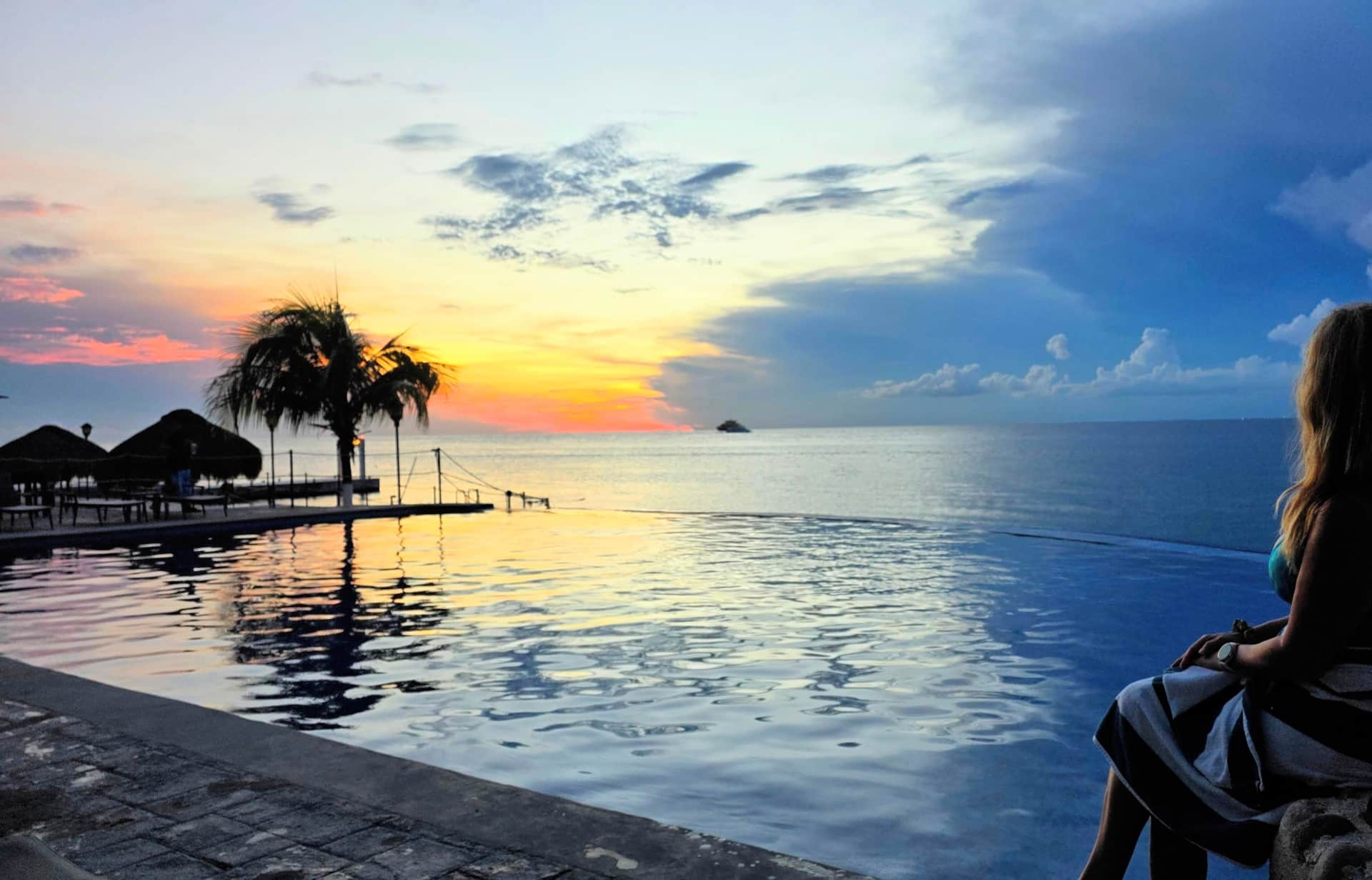 Leslie enjoying a peaceful sunset beside the infinity pool in Cozumel
