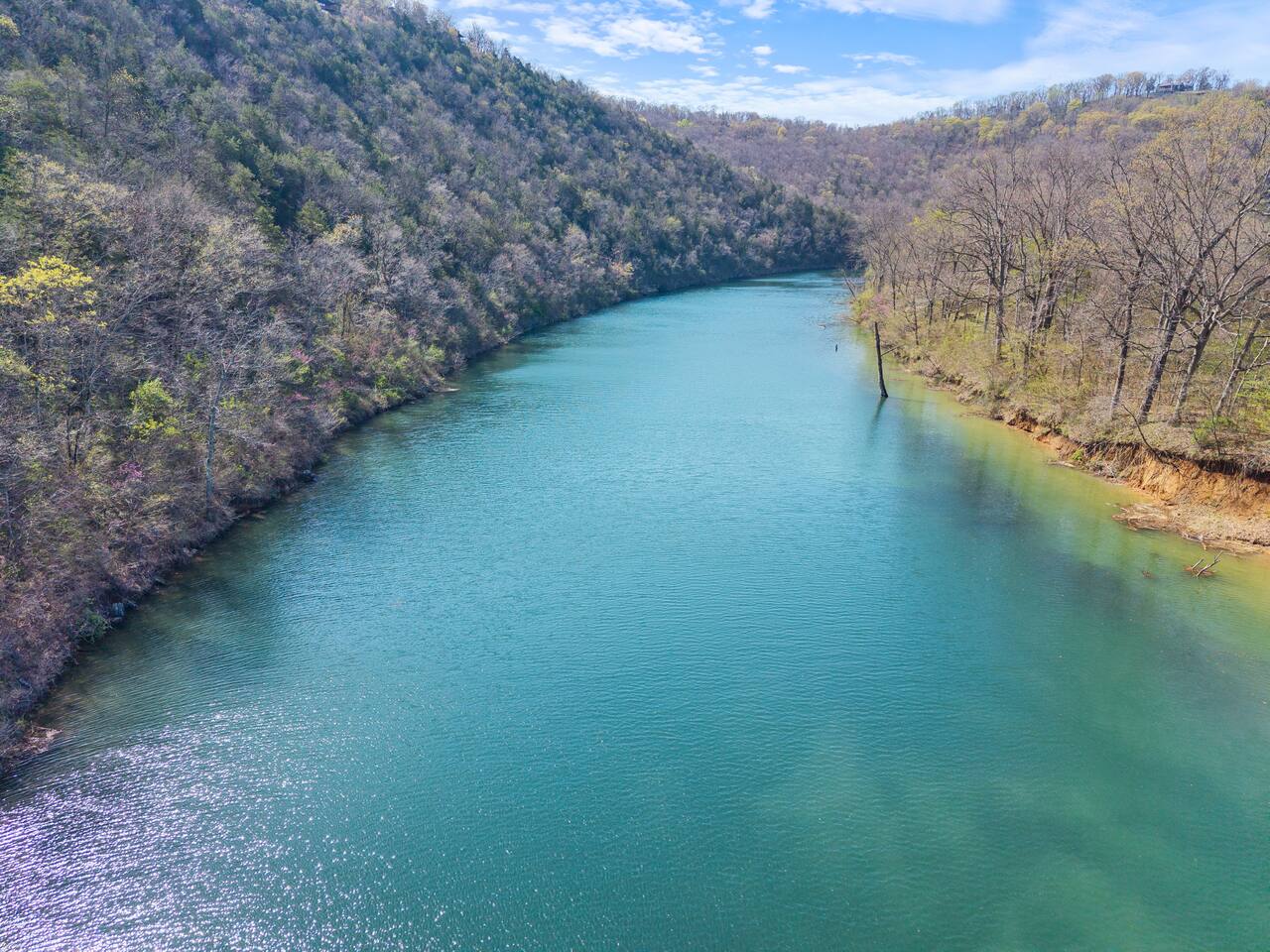Aerial view of a river surrounded by trees and hills.