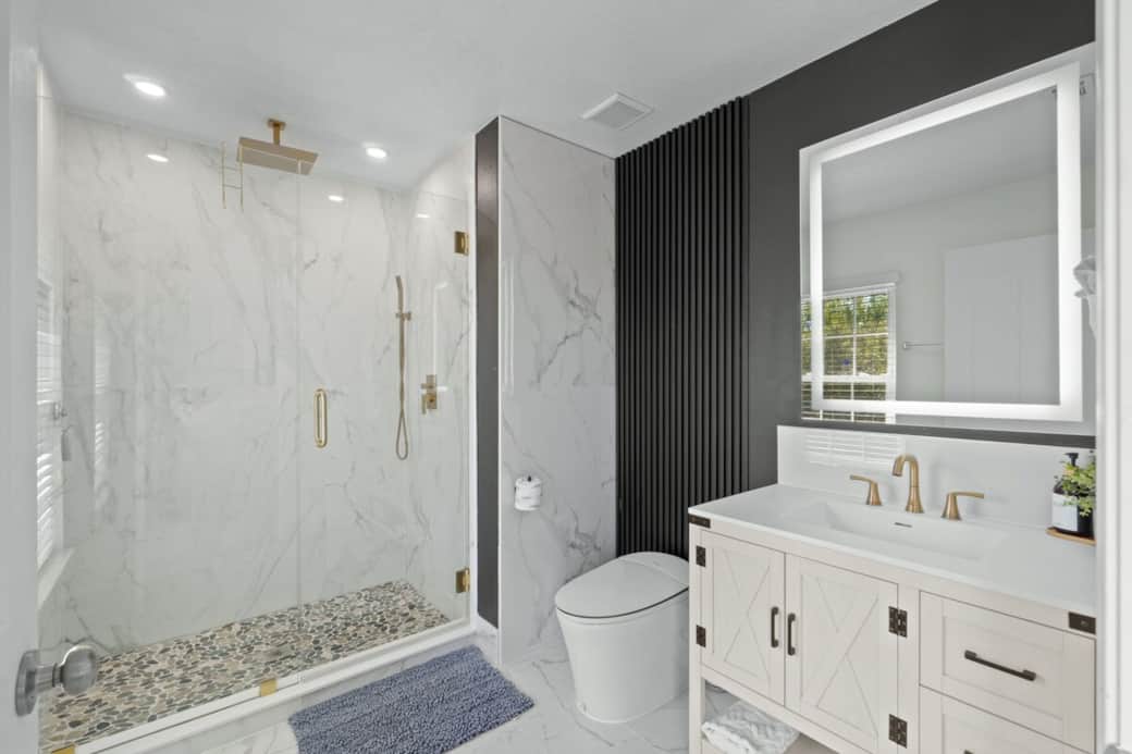 Bathroom has been modernized with a smart toilet that features a heated seat, automatic flushing, bidet functionality and self-cleaning capabilities. 