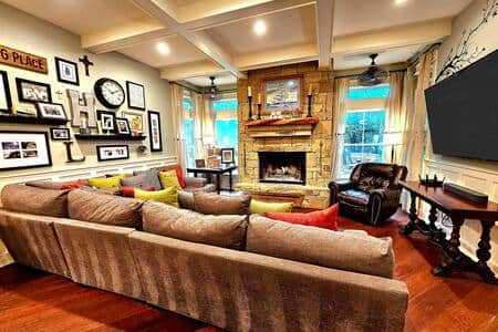 A cozy family room with a wood burning fireplace and loads of seating.