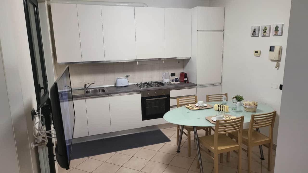 Küche mit Kochfeld, Backofen und gedecktem Tisch