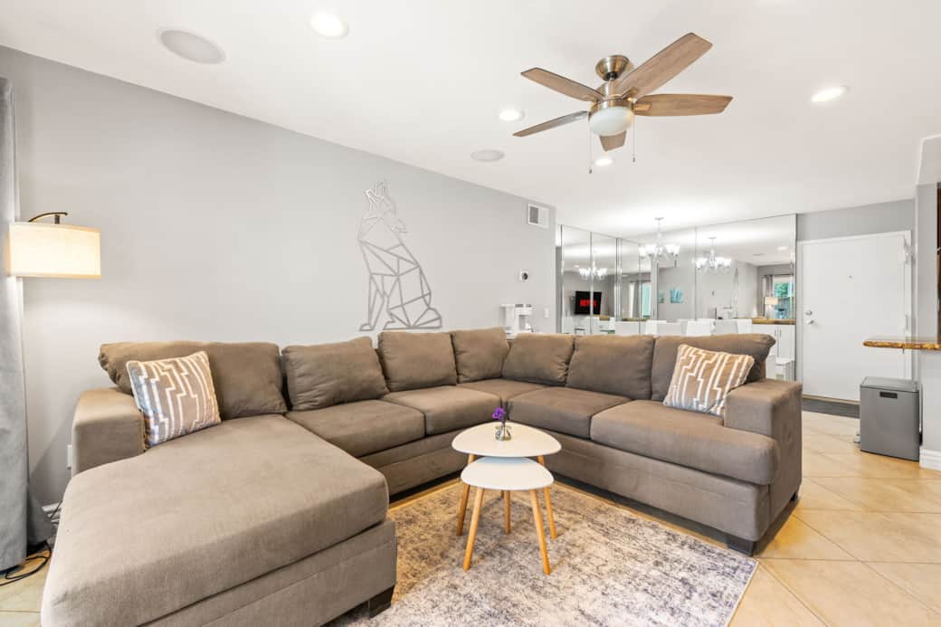 Spacious living room with comfy sectional, modern wall art- Spacious living room with comfy sectional, modern wall art-