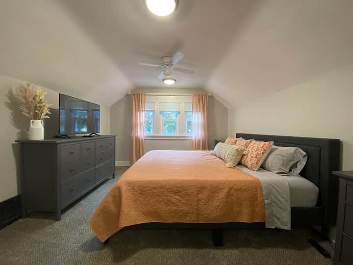 Bright and spacious bedroom with vaulted ceilings and soft natural light.