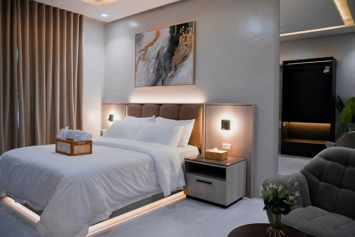 Relax in a stylish hotel-like studio with warm lighting and a 5-star queen bed.