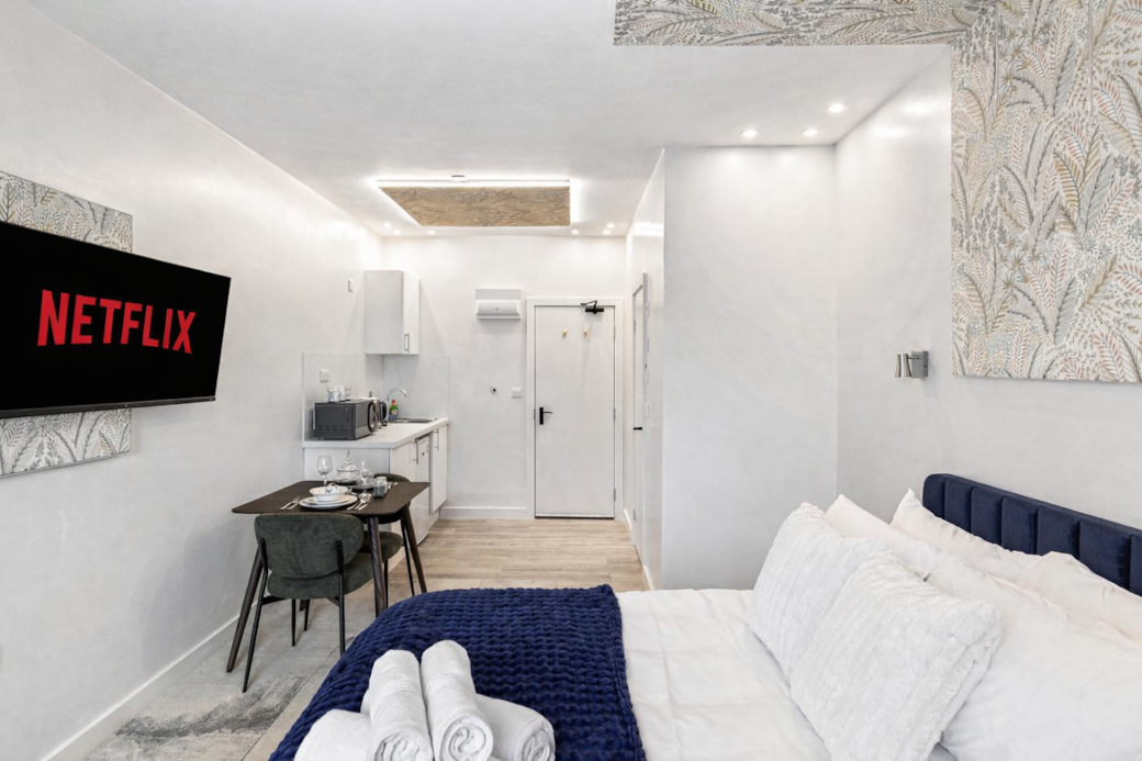 Bright and stylish bedroom featuring a plush double bed with luxury linens, feature wallpaper Bright and stylish bedroom featuring a plush double bed with luxury linens, feature wallpaper