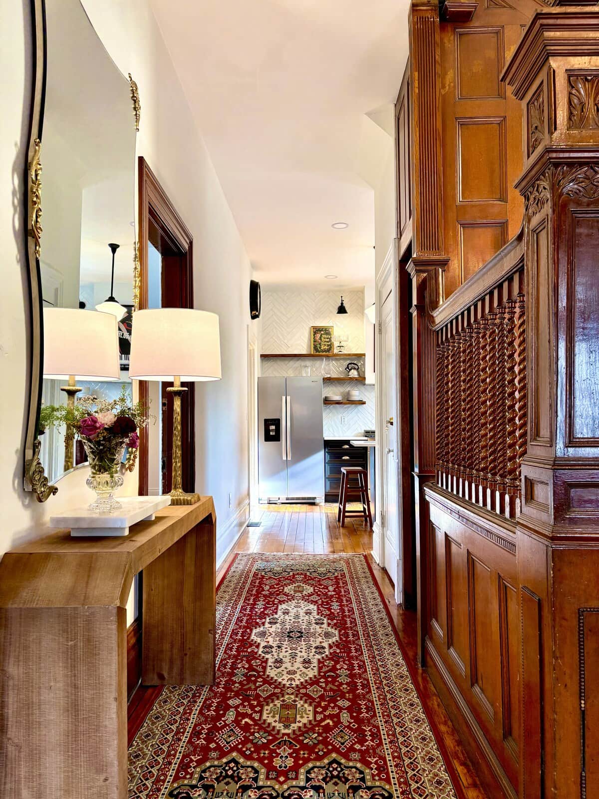 The entry hall on a bright afternoon, high ceilings opening all the way back to the kitchen