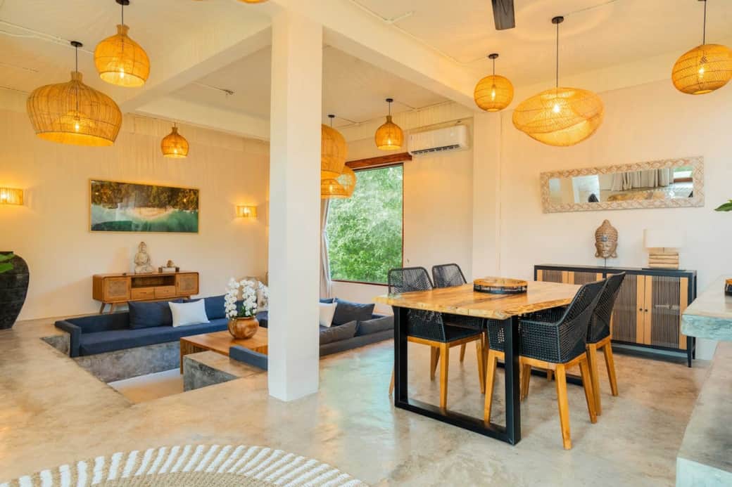 Enjoy long conversations and cozy dinners in Villa Yaro’s open-concept living and dining room. From rattan lighting to jungle-framed windows and handmade wooden furniture, this space is perfect for connecting and unwinding after a day in paradise.