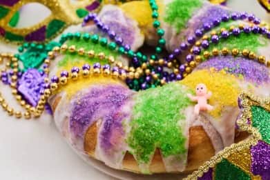 Colorful Mardi Gras king cake topped with purple, green, and gold sugar