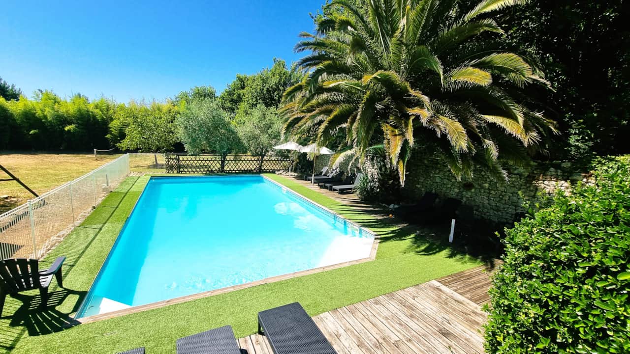 Heated swimming pool with no overlooking neighbors, surrounded by palm trees